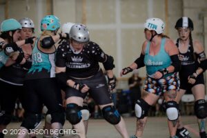 Ursa Maimer blocks against members of Akron Roller Derby. Photo by Jason Bechtel